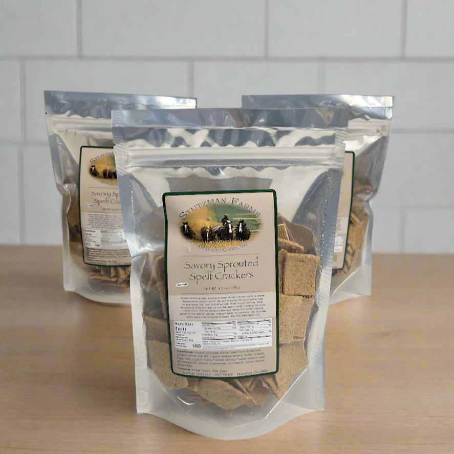 Packaged savory sprouted spelt crackers displayed on a table.