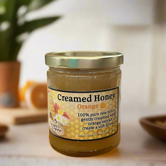 Jar of 'Creamed Honey Orange' on a kitchen counter with a blurred background