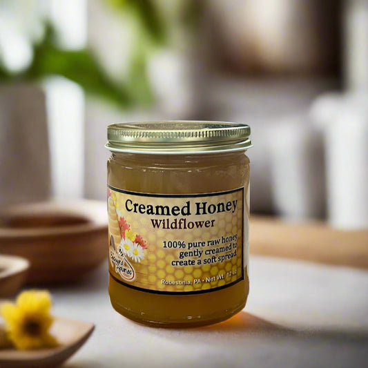 Jar of creamed honey labeled 'Wildflower' on a blurred background